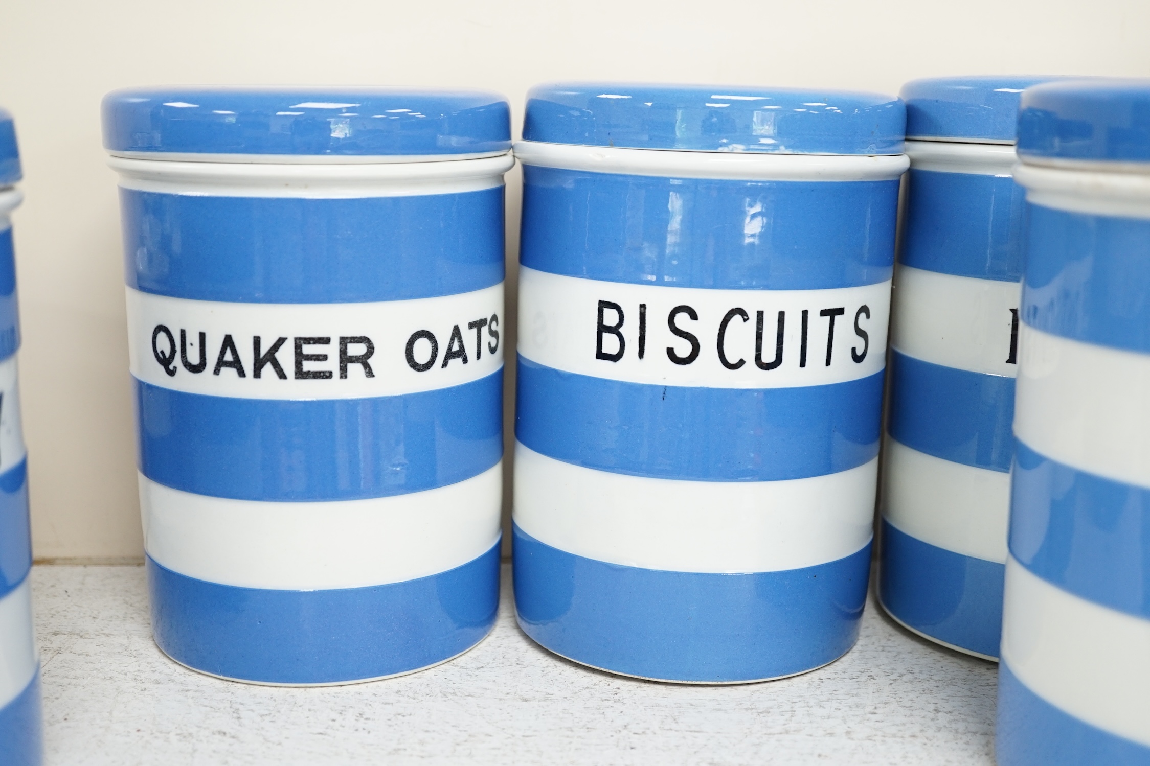 T.G.Green Cornish Kitchenware, eight 17cm lidded storage jars, comprising Currants, Caster Sugar, Granulated Sugar, Indian Tea, Macaroni, Biscuits, Pearl Barley and Quaker, Oats, Black Shield marks. Condition - fair to g
